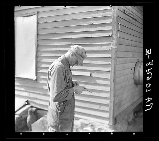 Tip Estes, forty-three year old hired man and father of nine children, whittling on a piece of wood. Near Fowler, Indiana