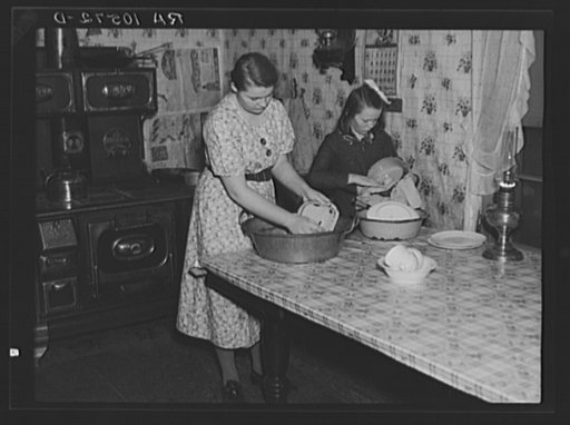6:15 a.m. Breakfast is over in the home of Tip Estes, hired man near Fowler, Indiana. And his two oldest daughters are washing dishes