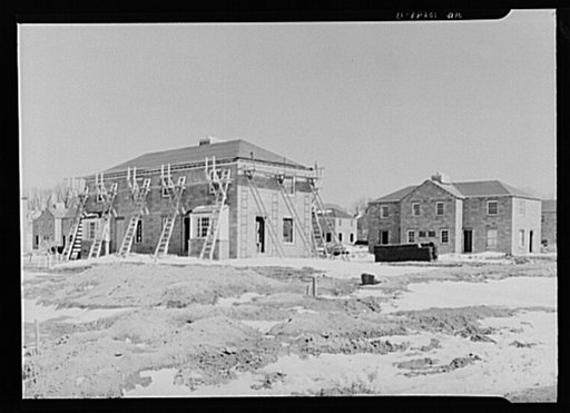 A group of houses under construction at Greendale, Wisconsin. Scaffolding has been erected for the building of the roof and application of shingles