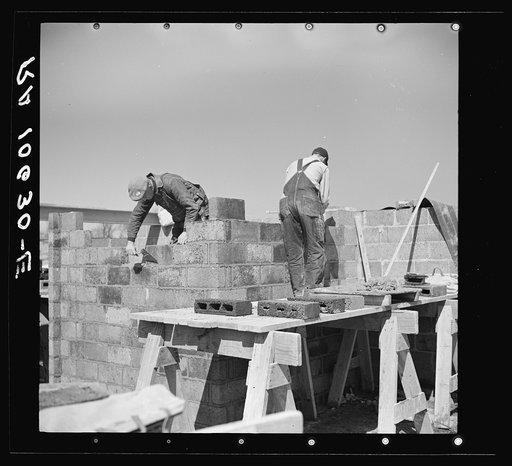 Laying cinder blocks on a house under construction at Greendale, Wisconsin