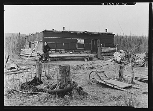 Ethel Allen, daughter of Lon Allen, standing in front of the family home. Iron County, Michigan