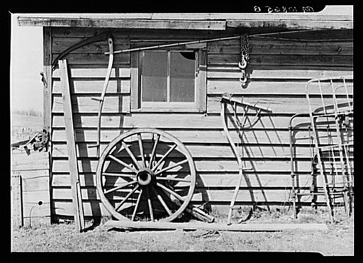 Machinery against the garage on Matt Henry's farm near Tipler, Wisconsin. Note primitive scythe rake