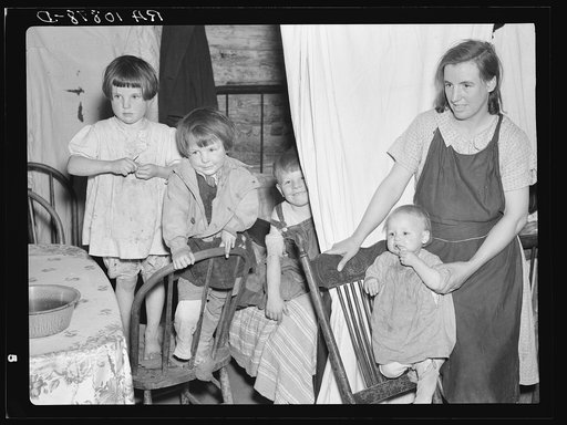 Children of Mrs. Bodray's daughter in their shack near Tipler, Wisconsin. A sheet separates the front part of their one-room shack from the rear