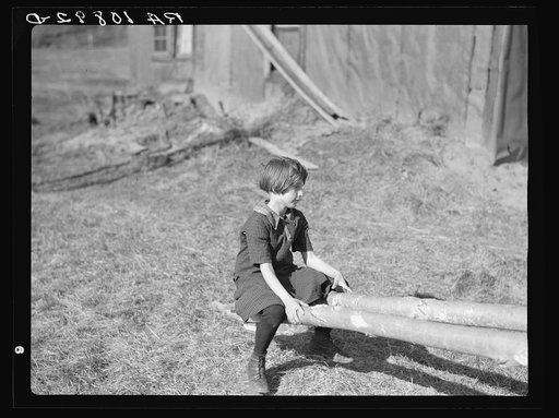 One of the Max Sparks' children playing on homemade teeter-totter near Long Lake, Wisconsin