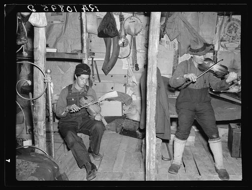Lon Allen and his son playing their fiddles to the tune of "The Arkansas Traveler." The fiddle played by the son was made by him. Near Iron River, Michigan