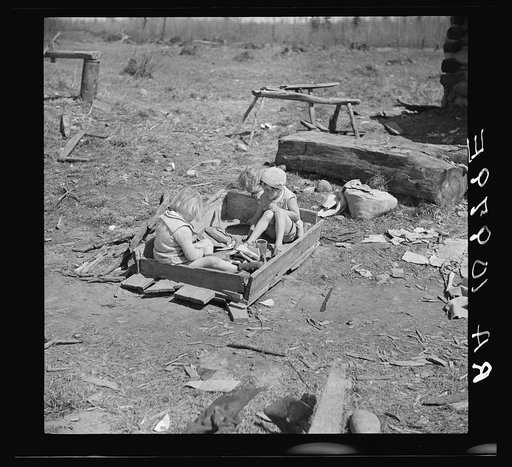Two of the Bodray children at play in their sandpile on a cut-over farm near Tipler, Wisconsin