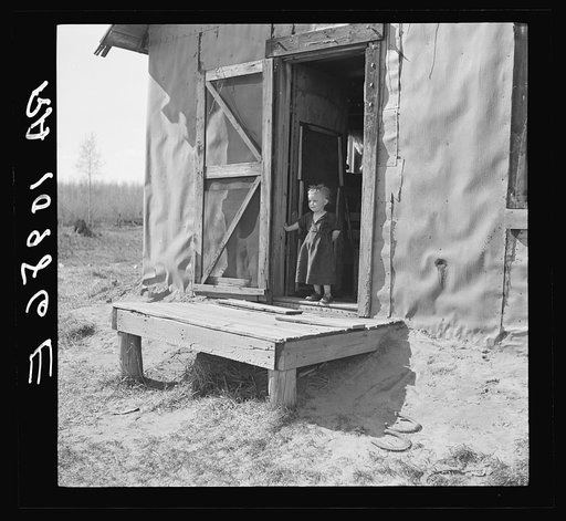 Max Sparks' youngest child standing in the doorway of his shack home near Long Lake, Wisconsin. She is a deaf mute