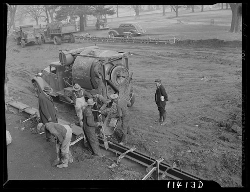 Washington, D.C. Construction of a bridge and road near Independence Avenue and 14th and 16th Streets, S.W. Pouring concrete into a curb form from a transit mix truck