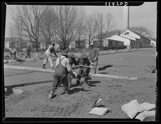 Washington, D.C. Construction of a bridge and road near Independence Avenue and 14th and 16th Streets, S.W.  Men shoveling the concrete to fill in low spots