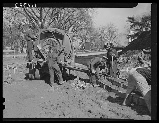 Washington, D.C. Construction of a bridge and road near Independence Avenue and 14th and 16th Streets, S.W. Pre-mixed concrete being poured into curb forms from a truck mixer