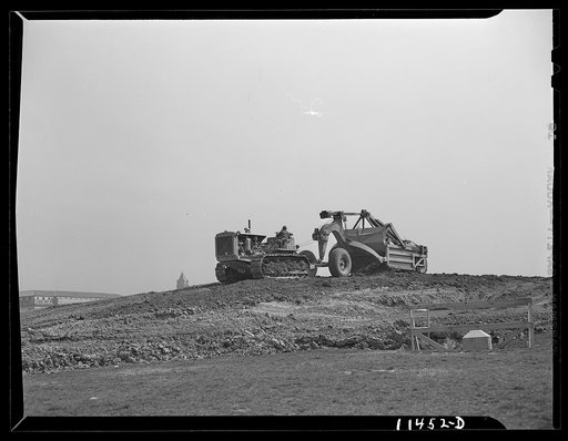 Washington, D.C. Construction of temporary war emergency buildings on the Mall, near 16th and 17th Streets, N.W. Le Tourneau earth mover and caterpillar tractor being used to move the top soil from the building site. The machine was also used to dig the basements