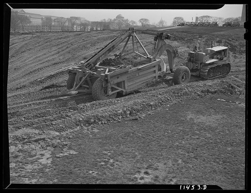 Washington, D.C. Construction of temporary war emergency buildings on the Mall, near 16th and 17th Streets, N.W. Le Tourneau earth mover and caterpillar tractor being used to move the top soil from the building site. The machine was also used to dig the basements