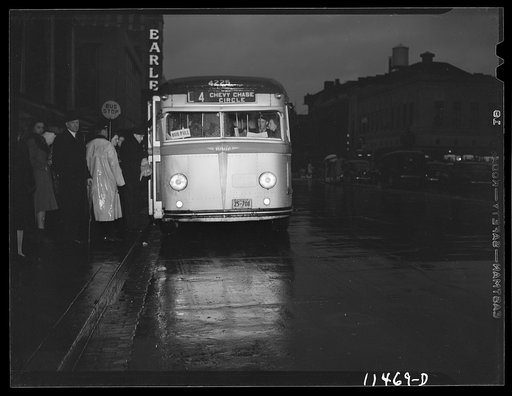 Washington, D.C. People boarding a bus on 13th Street on a rainy night