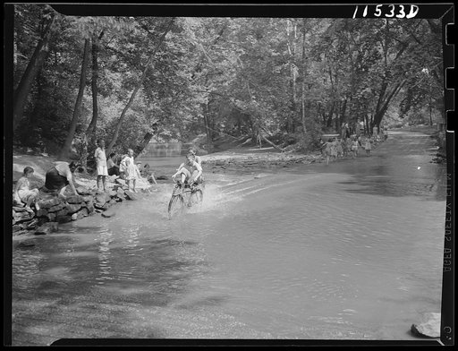 Washington, D.C. Boys riding bicycles across the ford in Rock Creek Park