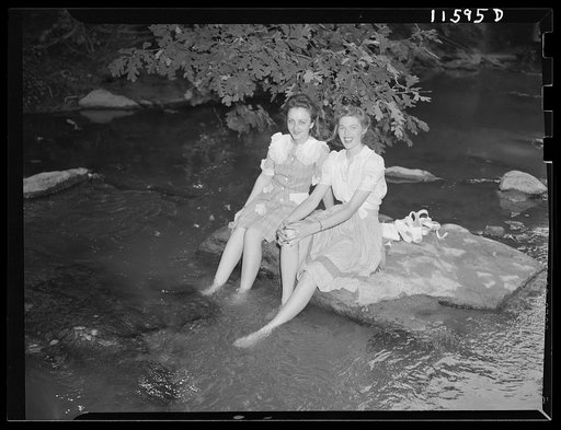 Washington, D.C. Girls on a hot day holding their feet in water in Rock Creek Park