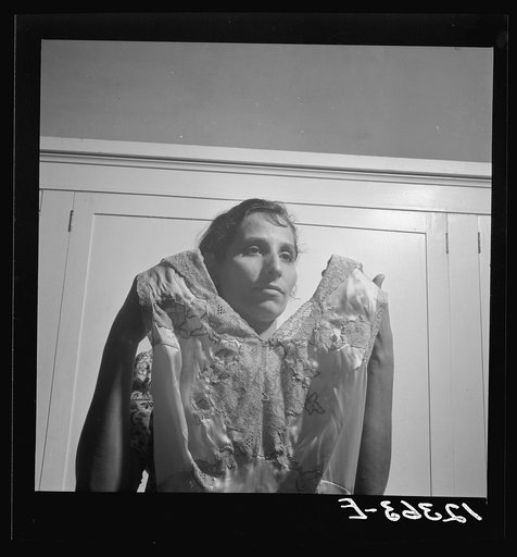 A member of the P.R.R.A. (Puerto Rico Resettlement Project) needlework cooperative holding up a sample of work. San Juan, Puerto Rico