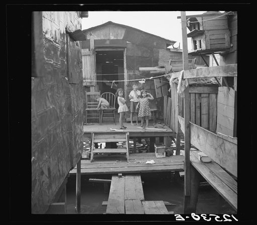 Slum dwellings in the workers' quarter of Porta De Tierra. Note: shacks are built on piles driven into swamp. Under the boards is open water. This place is infested with malarial mosquitoes. San Juan, Puerto Rico