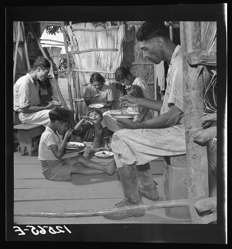 Jibaro family eating their main meal: rice, beans and a few pieces of codfish. Near Cidra, Puerto Rico