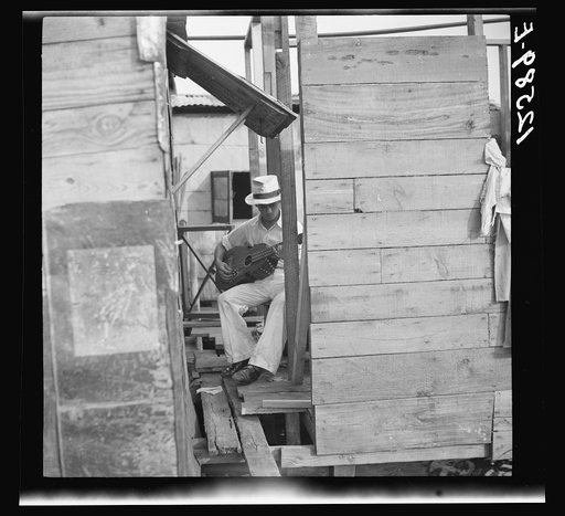 Guitar player above the swamp water. The workers' quarter of Puerto de Tierra. San Juan, Puerto Rico