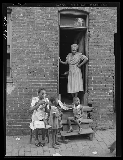 Negro family and their home in one of the alley dwellings. Washington, D.C.