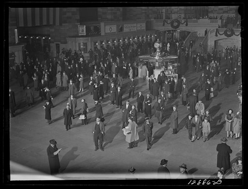 New York, New York. Installing the defense bond sales photomural prepared by the Farm Security Administration in the concourse of the Grand Central terminal. Crowd watching