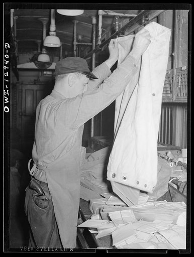 Emptying a sack of mail on board a mail car