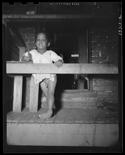 Washington, D.C. Child playing on the front porch of her [i.e. his] home