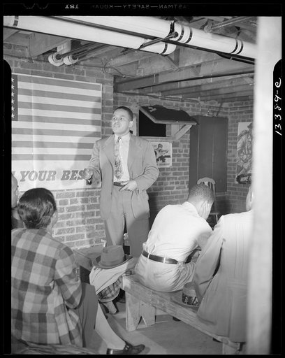 Washington, D.C. Air raid wardens' meeting in zone nine, Southwest area. Mr. Elmer House, federal worker by day and an air raid warden at night, outlining plans for his sector
