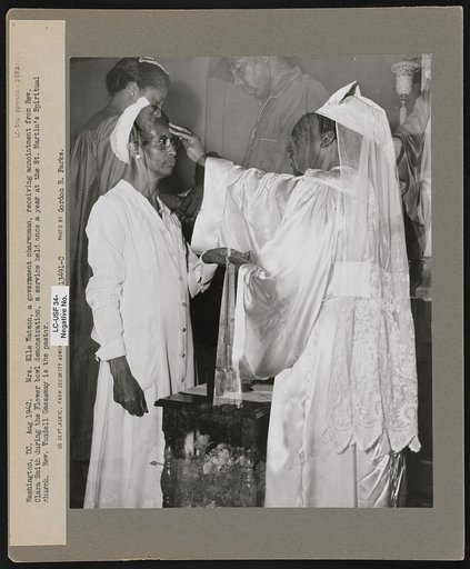 Washington, D.C. Mrs. Ella Watson, a government charwoman, receiving annointment from Reverend Clara Smith during the "flower bowl demonstration," a service held once a year at the St. Martin's Spiritual Church. Reverend Vondell Gassaway is the pastor