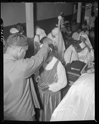 Washington, D.C. Reverend Vondell Gassway, pastor of the St. Martin's Spiritual Church, giving the final blessing and a flower to a member of his congregation during the annual "flower bowl demonstration"