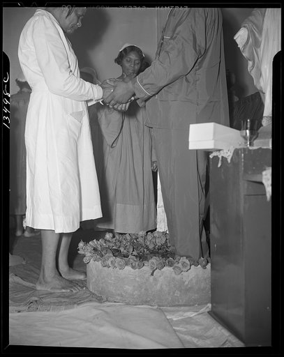 Washington, D.C. Reverend Vondell Gassaway, pastor of the St. Martin's Spiritual Church, giving the final blessing and a flower to a member of his congregation during the annual "flower bowl demonstration"
