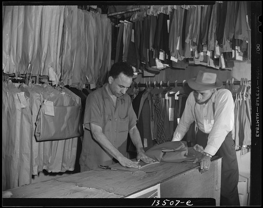 Washington, D.C. A tailor in Frank's cleaning and pressing establishment altering a pair of pants for a customer