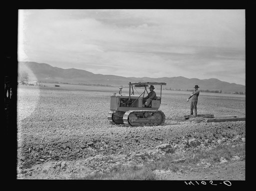 This tractor, whose ownership is cooperatively shared by brothers in the Summers family, serves the first Farm Security Administration community and cooperative service established in Box Elder County, Utah. Marion and Maymard Summers appear in the picture