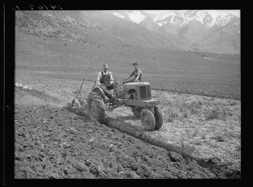 Orion W. Snow and his son drive the tractor bought with a Farm Security Administration rehabilitation loan, which plows land that Snow's horses could scarcely scrape. This farm is in Box Elder County, Utah