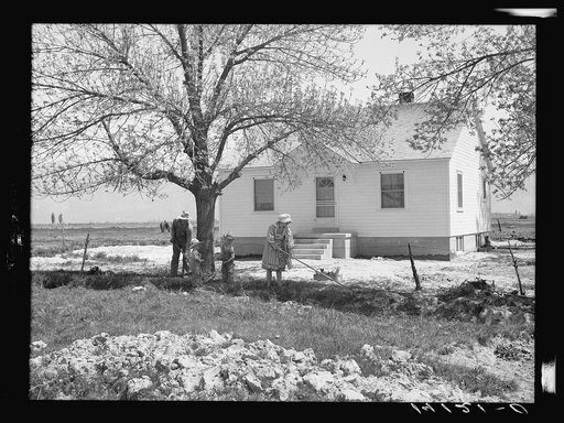 The Marvin R. Jeppesen family does some spring cleaning in front of the home built with part of their tenant purchase loan. This family is making a success on the first farm they have been able to own. In Box Elder County, Utah
