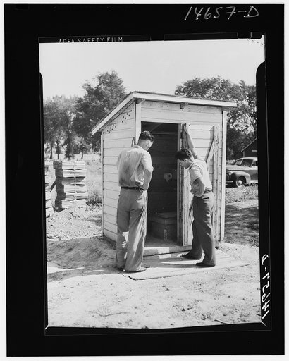 Completed sanitary privy in Minnesota being inspected by farmer and engineer of Farm Security Administration. Minnesota