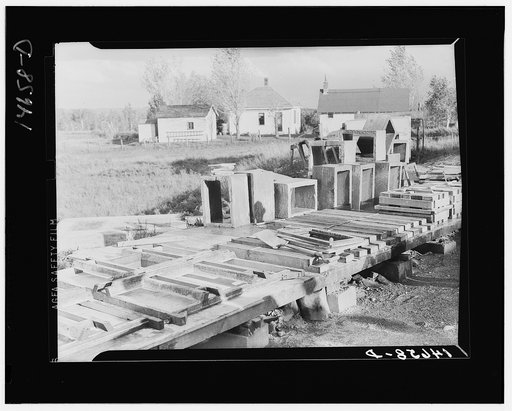 Concrete floor slabs, mud sills, and riser stools poured at central shop yard for farmers in Minnesota. Central construction permits economy in use of material. Minnesota