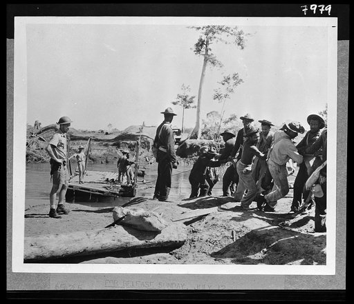 Untitled photo shows: Engineers constructing a temporary bridge in New Guinea