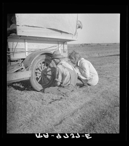 Untitled photo, possibly related to: Family between Dallas and Austin, Texas. The people have left their home and connections in South Texas, and hope to reach the Arkansas Delta for work in the cotton fields. Penniless people. No food and three gallons of gas in the tank. Father is trying to repair