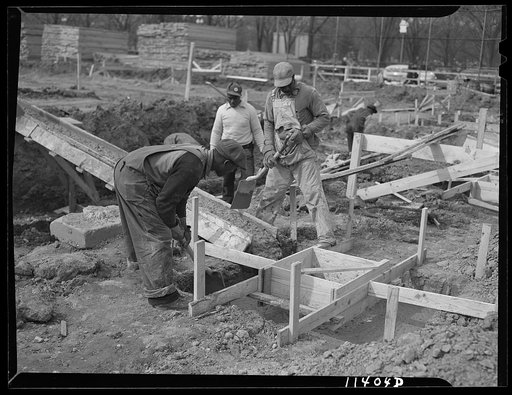 Untitled photo, possibly related to: Washington, D.C. Construction of temporary war emergency buildings on the Mall, near 16th and 17th Streets, N.W. After the concrete mixture has partly set, it is shoveled into the top form