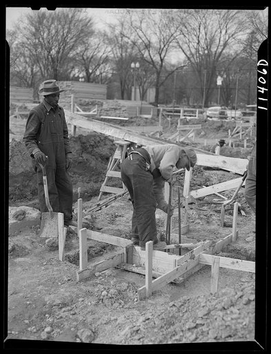 Untitled photo, possibly related to: Washington, D.C. Construction of temporary war emergency buildings on the Mall, near 16th and 17th Streets, N.W. After the concrete mixture has partly set, it is shoveled into the top form