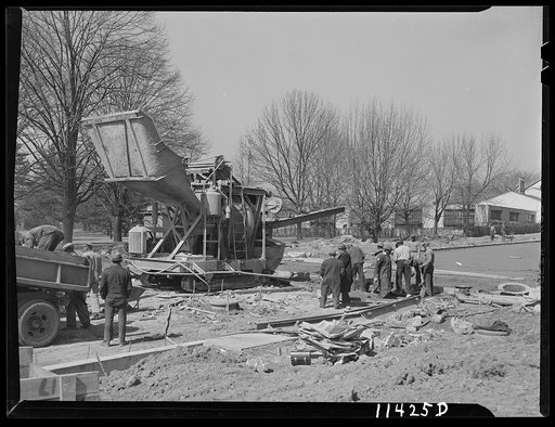 Untitled photo, possibly related to: Washington, D.C. Construction of a bridge and road near Independence Avenue and 14th and 16th Streets, S.W. The man in the foreground is shoveling concrete into a low spot