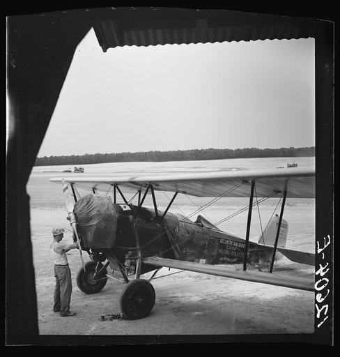 Untitled photo, possibly related to: Loading "dust" (insect spray) into plane of agricultural crop spraying outfit. This particular group of flying insect killers follow the seasons from Florida to Jersey to New York State. Planes are usually old (new planes with sufficient carrying capacity are too