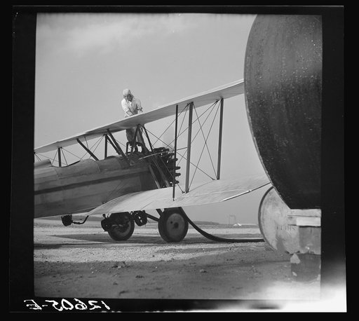 Untitled photo, possibly related to: Loading "dust" (insect spray) into plane of agricultural crop spraying outfit. This particular group of flying insect killers follow the seasons from Florida to Jersey to New York State. Planes are usually old (new planes with sufficient carrying capacity are too