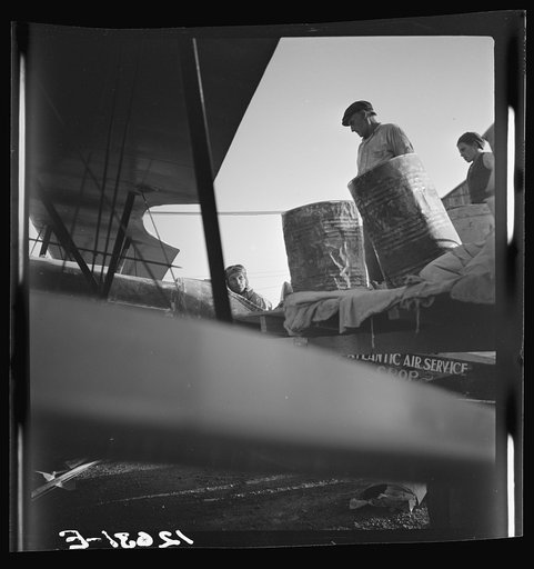 Untitled photo, possibly related to: Loading "dust" (insect spray) into plane of agricultural crop spraying outfit. This particular group of flying insect killers follow the seasons from Florida to Jersey to New York State. Planes are usually old (new planes with sufficient carrying capacity are too