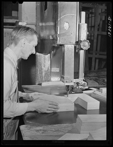 Untitled photo, possibly related to: New York, New York. Preparing the defense bond sales photomural, designed by the Farm Security Administration, to be installed in the Grand Central terminal, in the shop of a contractor. Cutting out plywood letters used for the text