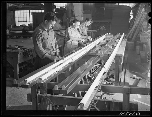 New York, New York. Preparing the defense bond sales photomural, designed by the Farm Security Administration, to be installed in the Grand Central terminal, in the shop of a contractor. Electricians wiring the flourescent lights used to illuminate the finished mural