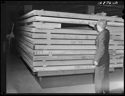 New York, New York. Preparing the defense bond sales photomural, designed by the Farm Security Administration, to be installed in the Grand Central terminal, in the shop of a contractor. Sections of one panel ready for installation