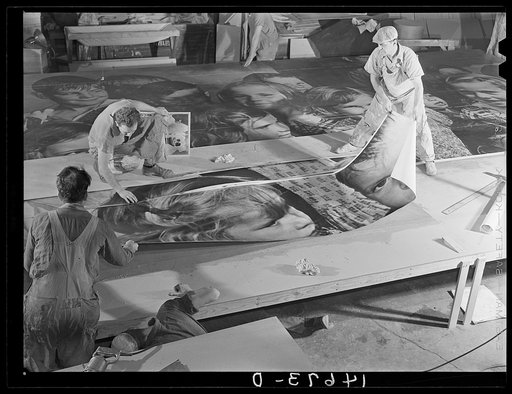 New York, New York. Preparing the defense bond sales photomural, designed by the Farm Security Administration, to be installed in the Grand Central terminal, in the shop of a contractor. Mounting central panel on the homosote board with flour paste