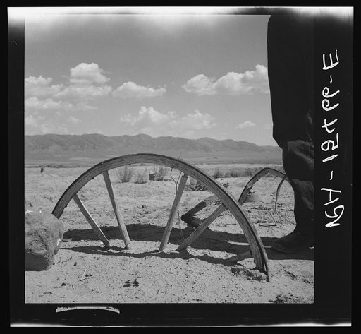 A brief cloudburst buries a wagon wheel to the axle as water erosion strips barren grazing land. On the Idaho land use project